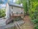 Home's rear exterior features a spacious deck, stairway to the yard, and a lush, wooded backdrop at 1625 Clark Lake Nw Dr, Acworth, GA 30102