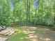 Large backyard with a wooden deck, playground and wooden fence blends into a private forested area at 1625 Clark Lake Nw Dr, Acworth, GA 30102