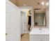Bright bathroom features a white vanity and framed mirror, and a peek at the tiled shower at 1625 Clark Lake Nw Dr, Acworth, GA 30102