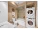 Bathroom with stacked washer and dryer near tiled bathtub at 1625 Clark Lake Nw Dr, Acworth, GA 30102