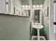 Powder room features a pedestal sink, decorative mirrors, and neutral wall color at 1625 Clark Lake Nw Dr, Acworth, GA 30102