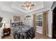 Bedroom showcases a tray ceiling, ceiling fan, and a comfortable bed by the bright window at 1625 Clark Lake Nw Dr, Acworth, GA 30102