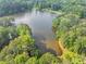 Aerial view of the winding community lake surrounded by mature trees and residential areas at 1625 Clark Lake Nw Dr, Acworth, GA 30102