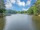 Panoramic view of the serene community lake surrounded by mature trees and blue skies at 1625 Clark Lake Nw Dr, Acworth, GA 30102