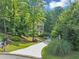 Charming two-story home with manicured front lawn and a long driveway lined with green trees at 1625 Clark Lake Nw Dr, Acworth, GA 30102