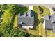 Aerial view of home showcasing backyard, large concrete patio, driveway, lush trees, and manicured lawn at 3313 Harmon Ridge Ct, Buford, GA 30519