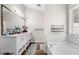 Bright bathroom featuring a double sink vanity, decorative rugs, and modern subway tile accents around the bathtub at 3313 Harmon Ridge Ct, Buford, GA 30519