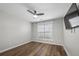 Well-lit bedroom with wood floors, a ceiling fan, and a window, offering a clean and simple design at 3313 Harmon Ridge Ct, Buford, GA 30519