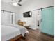 Bedroom featuring wood floors, vaulted ceilings, ceiling fan and an aqua sliding barn door to an en-suite bath at 3313 Harmon Ridge Ct, Buford, GA 30519