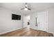Bright, airy bedroom with wood floors, a ceiling fan, a wall-mounted TV, and access to other rooms at 3313 Harmon Ridge Ct, Buford, GA 30519
