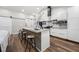 Modern kitchen featuring an island with seating, white cabinetry, stainless steel appliances, and wood-look flooring at 3313 Harmon Ridge Ct, Buford, GA 30519