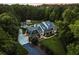 Stunning aerial view of estate home nestled among mature trees with detached garage and greenhouse at 390 Hembree Rd, Roswell, GA 30075