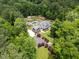 Aerial view of a beautiful estate featuring a large home, pool, garden, and surrounded by dense trees at 390 Hembree Rd, Roswell, GA 30075