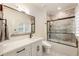Modern bathroom showcasing stylish vanity, a large mirror, and a glass-enclosed shower-over-tub combo at 390 Hembree Rd, Roswell, GA 30075