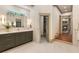 Well-lit bathroom featuring double sinks, modern fixtures, and an open doorway leading to the living room at 390 Hembree Rd, Roswell, GA 30075