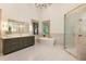 Bright bathroom featuring a double vanity, soaking tub, and glass shower at 390 Hembree Rd, Roswell, GA 30075