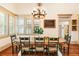 Bright dining room with wooden table set, chandelier, and ample natural light from large windows at 390 Hembree Rd, Roswell, GA 30075