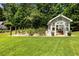 Backyard greenhouse surrounded by a garden and lawn at 390 Hembree Rd, Roswell, GA 30075