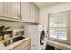Well-organized laundry room with modern washer and dryer units and ample cabinet space at 390 Hembree Rd, Roswell, GA 30075