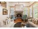 Cozy living room featuring a stone fireplace, comfortable seating, and stylish decor at 390 Hembree Rd, Roswell, GA 30075
