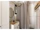 Pool house bathroom with vanity and striped shower curtain at 390 Hembree Rd, Roswell, GA 30075