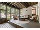 Comfortable screened porch featuring rustic wood furniture and views of the landscaped backyard at 390 Hembree Rd, Roswell, GA 30075