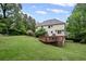 Expansive backyard with a wooden deck, lush lawn, and mature trees at 125 Winter Valley Ct, Fayetteville, GA 30215