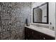 Stylish bathroom featuring decorative wallpaper, dark vanity with light countertop, and a large mirror at 125 Winter Valley Ct, Fayetteville, GA 30215