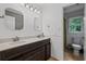Bathroom features a dark vanity with double sinks and a doorway to the toilet at 125 Winter Valley Ct, Fayetteville, GA 30215