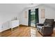 Bright bedroom features hardwood floors, a comfortable armchair, and a window letting in plenty of natural light at 125 Winter Valley Ct, Fayetteville, GA 30215
