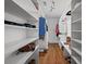 Spacious walk-in closet featuring built-in shelving and hardwood floors at 125 Winter Valley Ct, Fayetteville, GA 30215