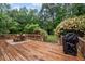Outdoor deck featuring a dining set, grill, and lush greenery, ideal for entertaining at 125 Winter Valley Ct, Fayetteville, GA 30215