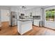 Bright eat-in kitchen featuring stainless appliances, white cabinets, an island, and hardwood floors at 125 Winter Valley Ct, Fayetteville, GA 30215