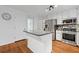 Updated eat-in kitchen featuring stainless appliances, white cabinets, an island with gray countertop, and hardwood floors at 125 Winter Valley Ct, Fayetteville, GA 30215