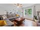 Open living room with hardwood floors, large gray couch, and stainless kitchen appliances visible in the background at 125 Winter Valley Ct, Fayetteville, GA 30215