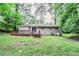 Backyard featuring a deck and spacious grassy area surrounded by lush trees at 1715 Lee St, Decatur, GA 30035