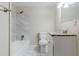 Bathroom featuring marble tiled wall, shower, toilet, and white vanity with granite countertop at 1715 Lee St, Decatur, GA 30035