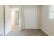 Bedroom showcasing a closet with sliding doors and an open doorway with beige walls and carpeted floors at 1715 Lee St, Decatur, GA 30035