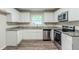 Well-equipped kitchen boasting stainless steel appliances, granite countertops, and white cabinets at 1715 Lee St, Decatur, GA 30035