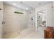 Bathroom featuring glass shower with seat, rain shower head, tiled walls, and view of bedroom at 178 Crestbrook Way, Dallas, GA 30157