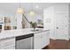 Beautiful kitchen island featuring white cabinets, stainless steel dishwasher, granite countertops and pendant lights at 178 Crestbrook Way, Dallas, GA 30157