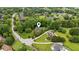 Aerial shot capturing a neighborhood with mature trees and the home, which has a well-manicured front lawn at 2610 Ginger Dr, Buford, GA 30519