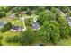 Aerial view shows mature trees surrounding a home with a pool and a serene pond, enhancing the property's appeal at 2610 Ginger Dr, Buford, GA 30519
