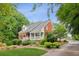 Brick home with inviting front porch, surrounded by lush landscaping and mature trees at 2610 Ginger Dr, Buford, GA 30519