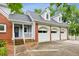 Home exterior featuring a three-car garage, brick accents, and well-manicured landscaping at 2610 Ginger Dr, Buford, GA 30519