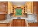 Kitchen features granite countertops, oak cabinets, and tile backsplash at 2610 Ginger Dr, Buford, GA 30519