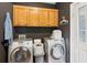 Laundry room featuring washer and dryer, utility sink, storage cabinets, and exterior door at 2610 Ginger Dr, Buford, GA 30519