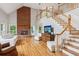 Bright living room with hardwood floors, fireplace, and a staircase leading to a second-story balcony at 2610 Ginger Dr, Buford, GA 30519