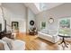 Spacious living room with hardwood floors, soaring ceilings, comfortable seating, and natural light from large windows at 2610 Ginger Dr, Buford, GA 30519
