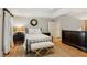 Comfortable main bedroom featuring wood floors, tray ceiling, wrought iron bed frame, and an area rug at 2610 Ginger Dr, Buford, GA 30519